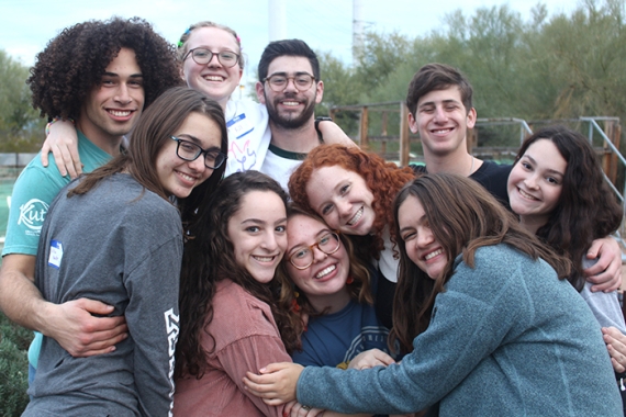A group of NFTY teens embrace while smiling